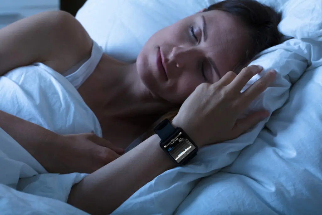 Eine zufriedene Frau liegt im Bett und schläft.
